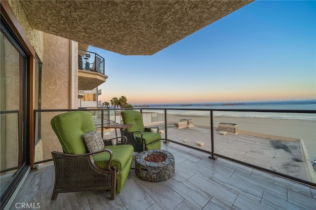 balcony at dusk featuring a water view