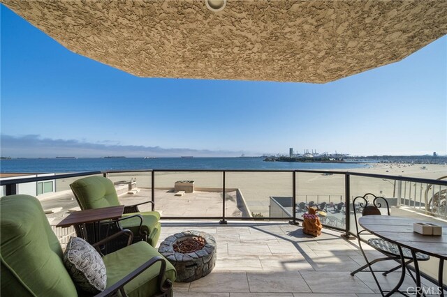 balcony featuring a water view and a view of the beach