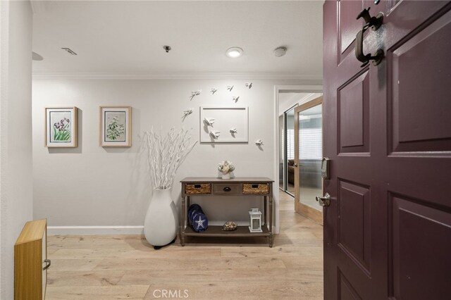 corridor featuring ornamental molding and light wood-type flooring