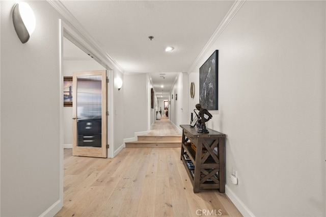 hallway with light hardwood / wood-style floors and ornamental molding