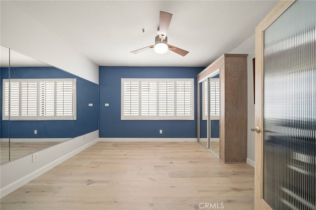 unfurnished bedroom with baseboards, ceiling fan, and light wood finished floors