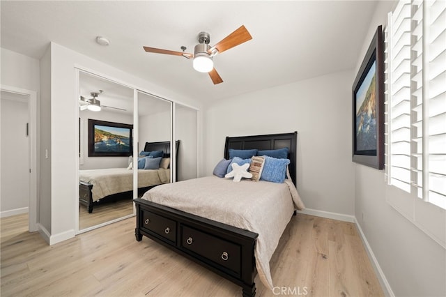 bedroom with light wood-type flooring, a closet, ceiling fan, and baseboards