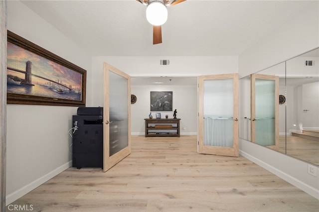 corridor with french doors, visible vents, and light wood finished floors