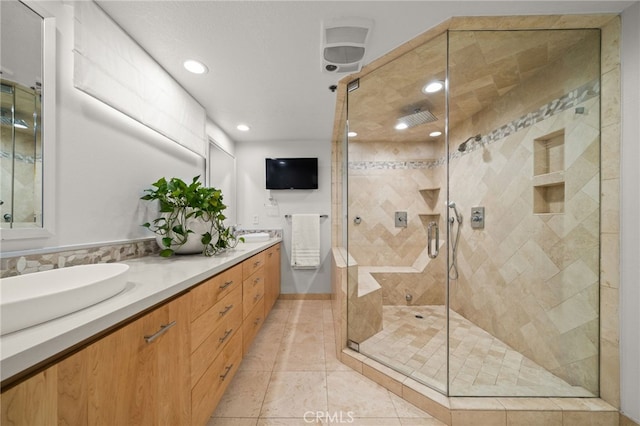 full bath featuring double vanity, a stall shower, tile patterned flooring, a sink, and recessed lighting