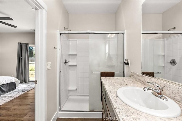 bathroom with vanity, ceiling fan, hardwood / wood-style flooring, and a shower with door
