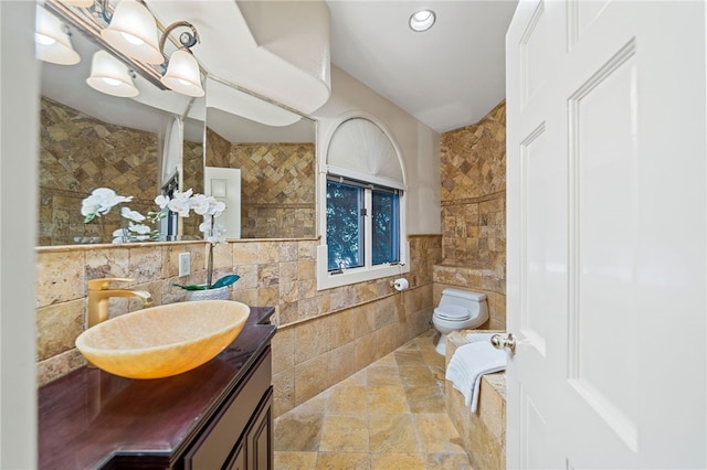 bathroom featuring tile walls, toilet, and vanity