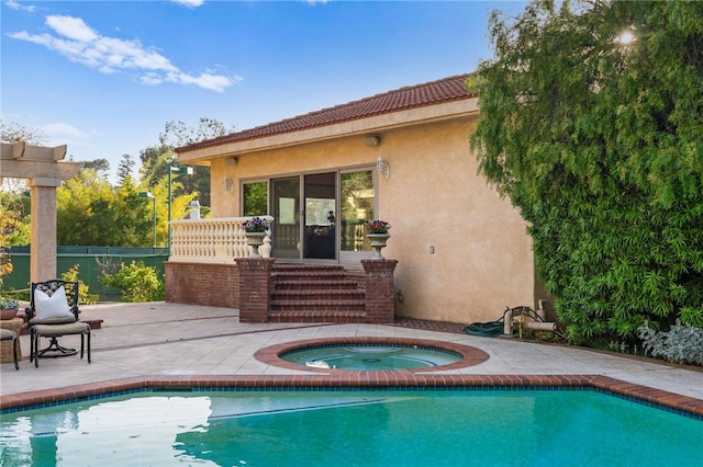 back of property featuring a pool with hot tub and a patio area