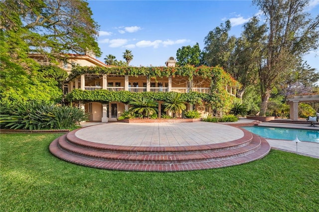 view of pool with a patio area and a lawn