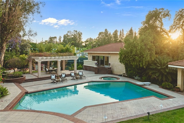 view of swimming pool with a diving board, a pergola, a patio area, and an in ground hot tub