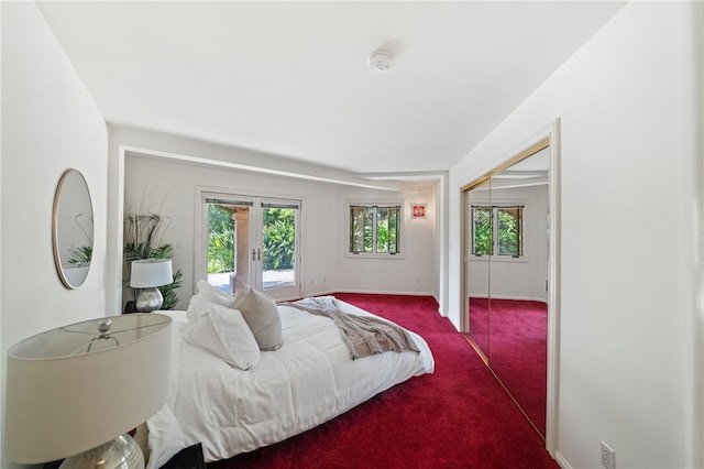 bedroom featuring a closet, carpet flooring, and french doors