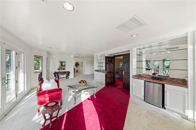 carpeted living room featuring indoor bar and french doors