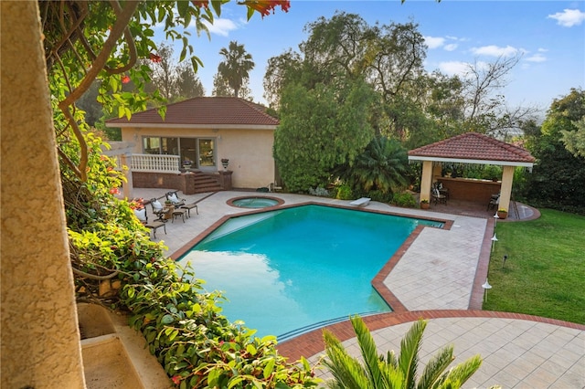 view of pool with an in ground hot tub, a gazebo, a diving board, a patio, and a lawn