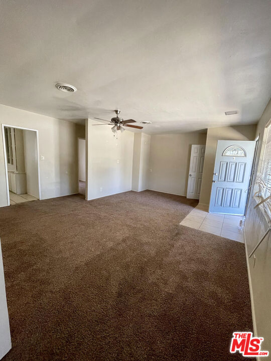 interior space featuring light carpet and ceiling fan