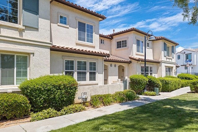 mediterranean / spanish-style house with a front lawn