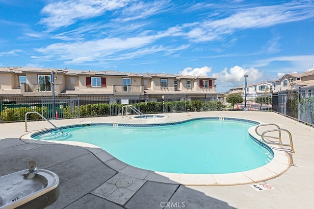 view of swimming pool featuring a patio area and a hot tub