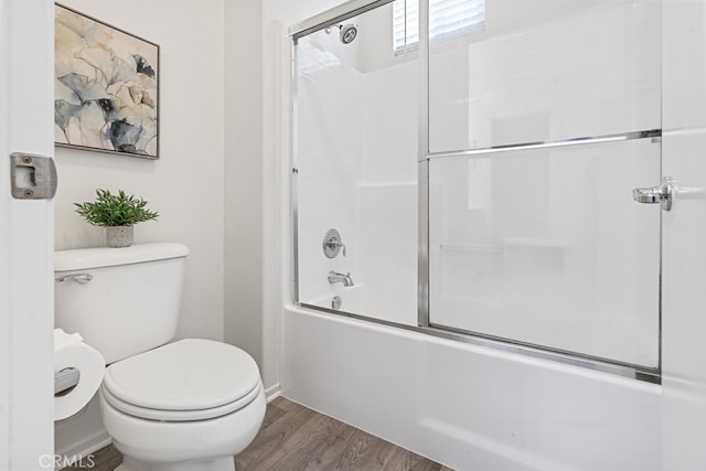 bathroom with hardwood / wood-style floors, combined bath / shower with glass door, and toilet