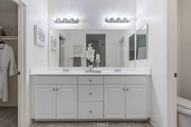 bathroom featuring double vanity and toilet