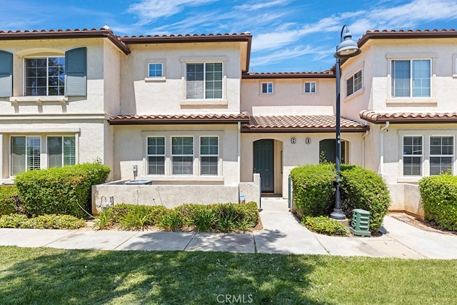 mediterranean / spanish-style house with a front lawn