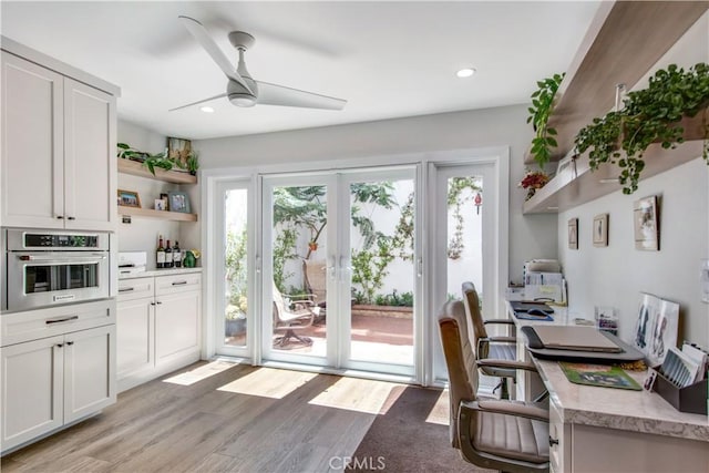 home office featuring ceiling fan, light wood-type flooring, and a wealth of natural light