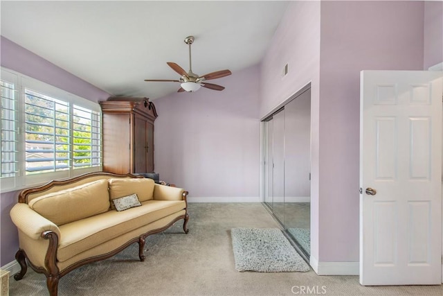 sitting room featuring ceiling fan, light colored carpet, and vaulted ceiling