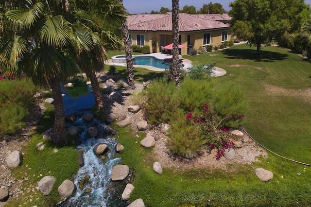 exterior space featuring a swimming pool with hot tub and a patio