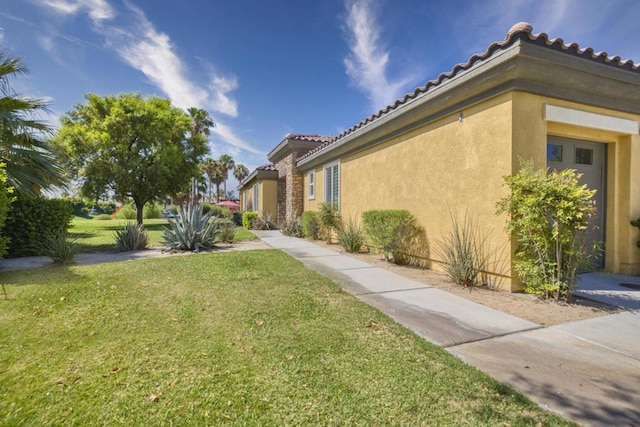 view of side of home with a yard