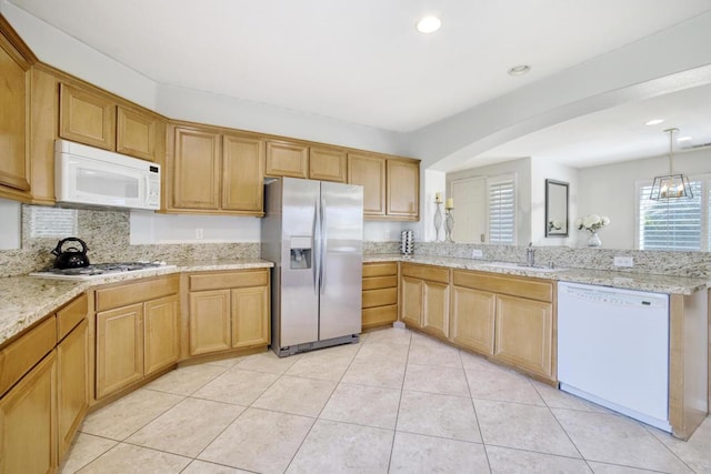 kitchen with sink, decorative light fixtures, kitchen peninsula, stainless steel appliances, and a chandelier