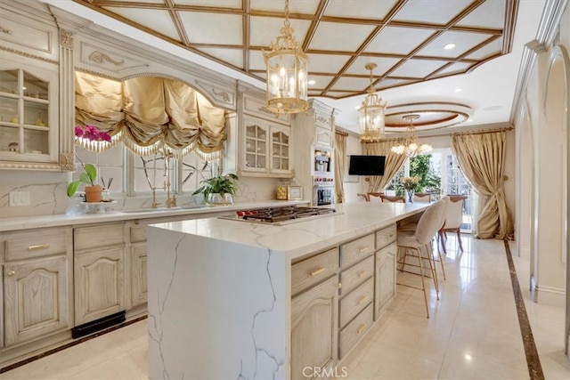 kitchen with an inviting chandelier, hanging light fixtures, stainless steel gas stovetop, and a center island