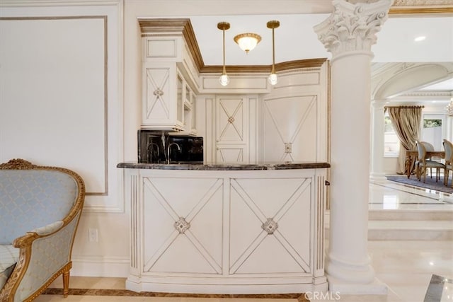 bar featuring cream cabinetry, dark stone countertops, pendant lighting, crown molding, and decorative columns