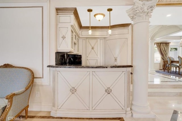 interior space with ornate columns, dark stone countertops, crown molding, and hanging light fixtures
