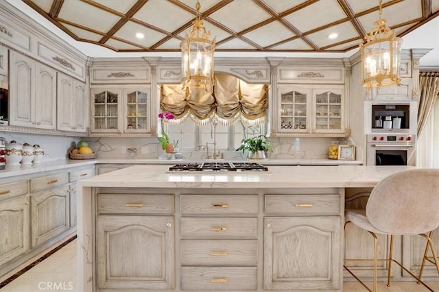 kitchen with an inviting chandelier, stainless steel appliances, pendant lighting, and cream cabinetry