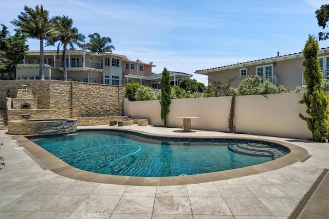 view of pool featuring a fireplace, fence, a fenced in pool, and an in ground hot tub