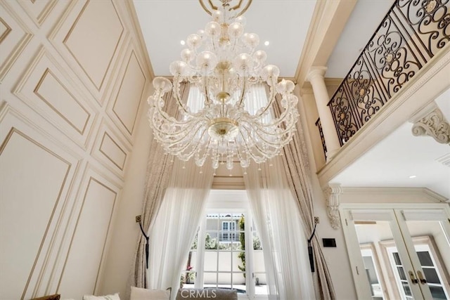interior details featuring french doors, crown molding, and a chandelier