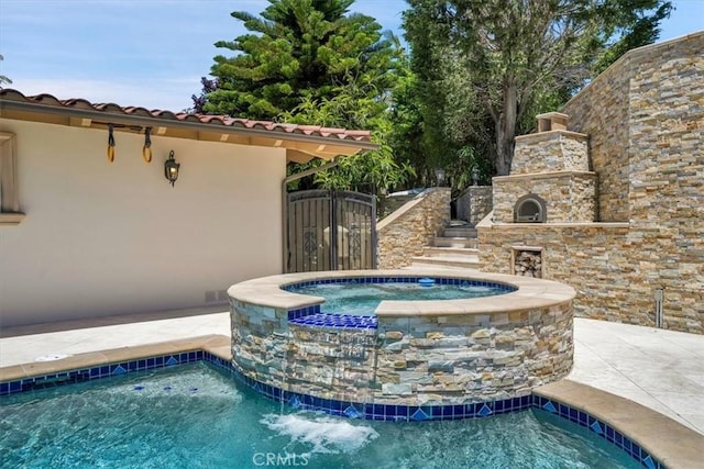 exterior details featuring stucco siding, a fireplace, stone siding, and a jacuzzi