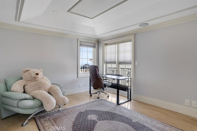 bedroom featuring ornamental molding, light wood-type flooring, and a tray ceiling