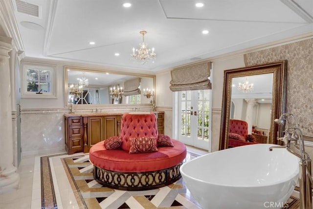 bathroom with wainscoting, ornamental molding, recessed lighting, and an inviting chandelier