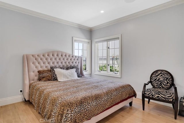 bedroom with baseboards, ornamental molding, and light wood-type flooring