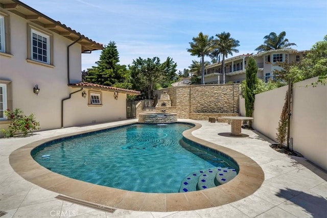 view of swimming pool featuring a fenced backyard, a pool with connected hot tub, and a patio area
