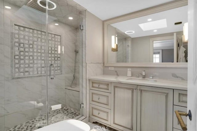 full bath with a skylight, recessed lighting, vanity, and a shower stall
