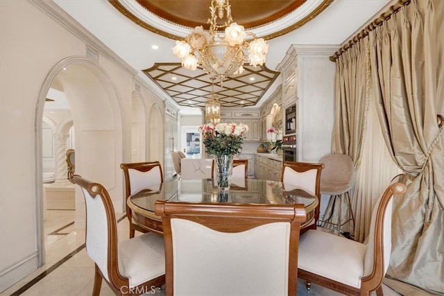 tiled dining room featuring a raised ceiling, ornamental molding, and a notable chandelier