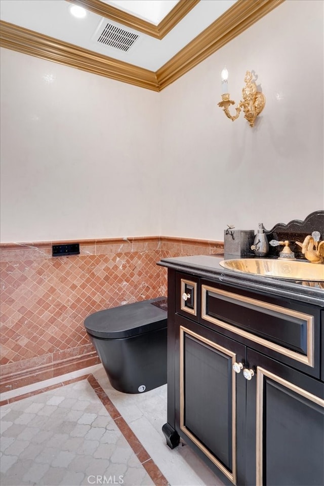 interior space featuring tile walls, tile patterned flooring, crown molding, vanity, and toilet