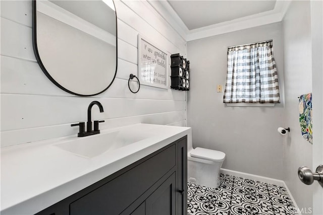 bathroom with toilet, vanity, and ornamental molding