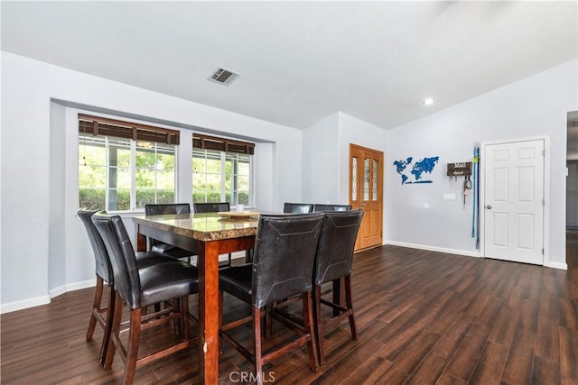 dining area featuring lofted ceiling and dark hardwood / wood-style floors