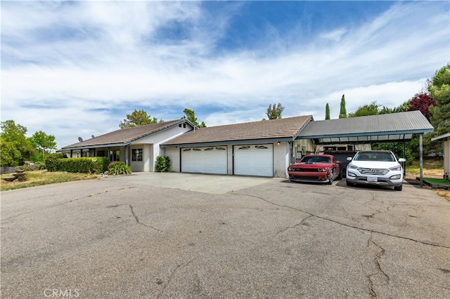 ranch-style home featuring a garage and a carport