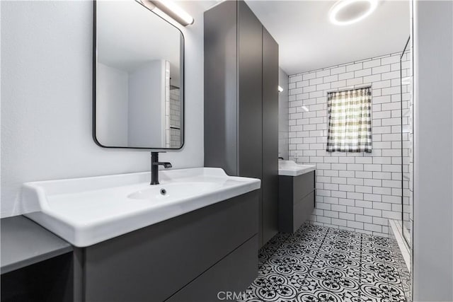 bathroom with tile walls, tiled shower, and vanity