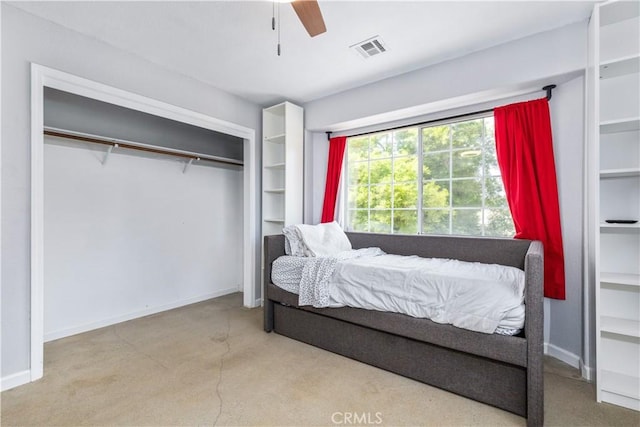 bedroom with light carpet, ceiling fan, and a closet