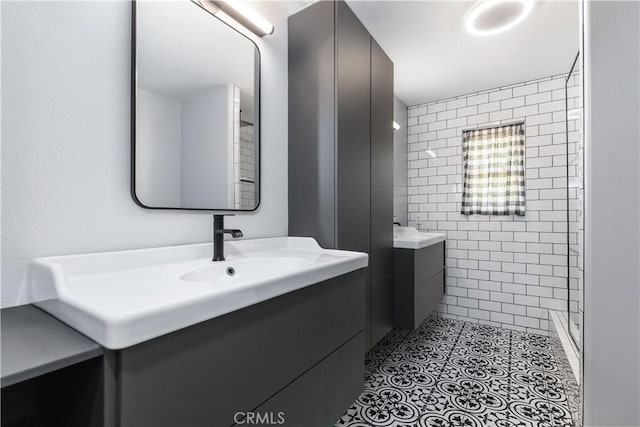 bathroom with tiled shower and vanity