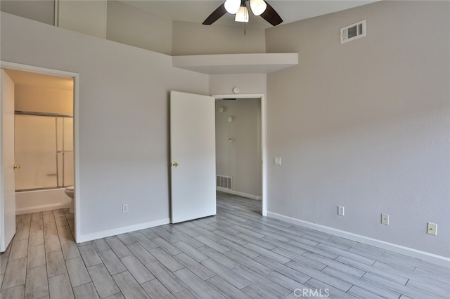 unfurnished bedroom with light hardwood / wood-style floors, ensuite bath, and ceiling fan