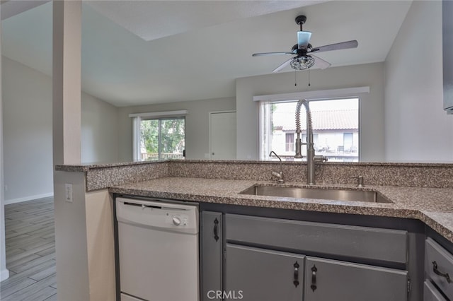 kitchen featuring wood-type flooring, dishwasher, sink, vaulted ceiling, and ceiling fan