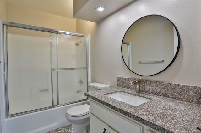 full bathroom with shower / bath combination with glass door, vanity, hardwood / wood-style floors, and toilet